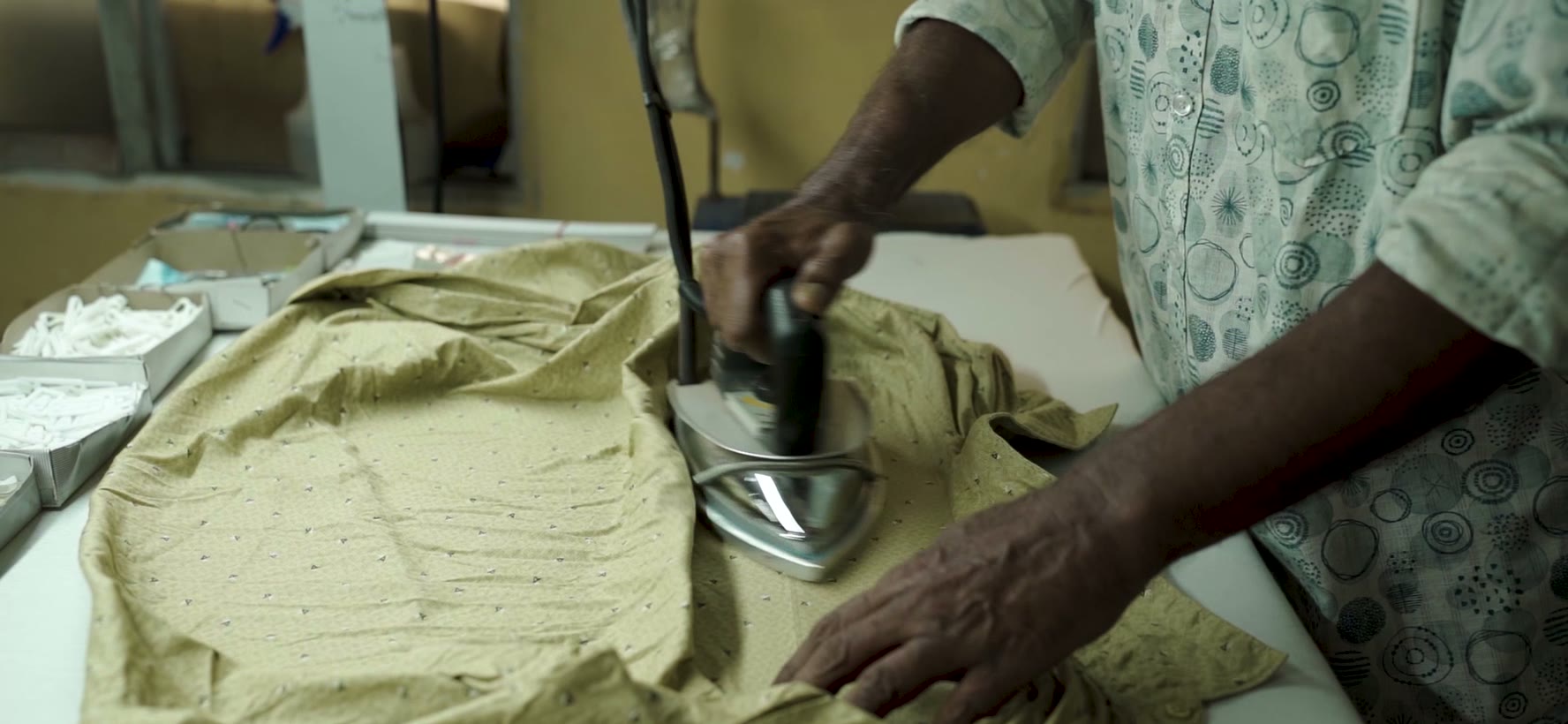 Pressing a finished shirt on the steam iron section